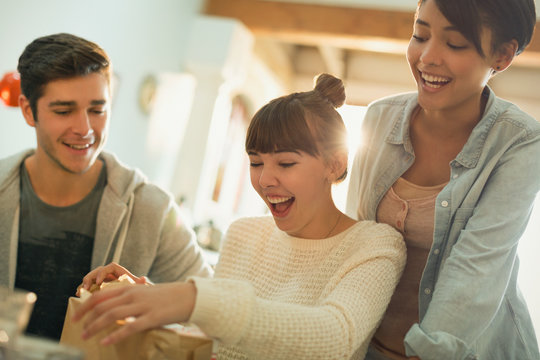 Young friends celebrating birthday opening gift
