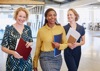 Smiling businesswomen walking in office