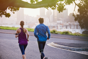 Runner couple running on urban city street