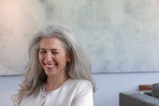 Mature woman laughing with eyes closed