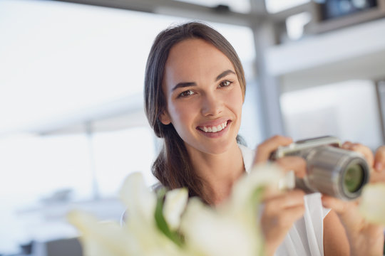 Portrait smiling brunette woman using digital camera