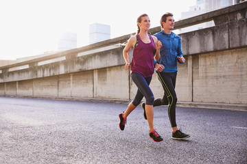Runner couple running on urban street