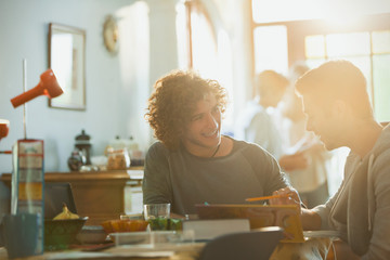 Young men college students studying at sunny dining table