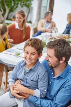 Portrait smiling father and son enjoying patio lunch