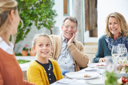 Multi-generation family enjoying lunch at patio table