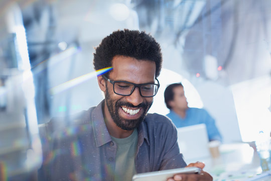 Smiling, confident businessman using digital tablet