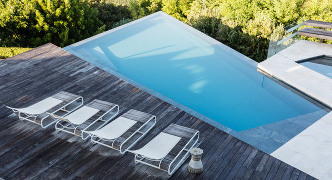 Modern, luxury deck with lounge chairs and swimming pool