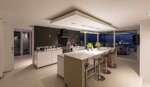 Illuminated modern luxury home showcase interior kitchen at night