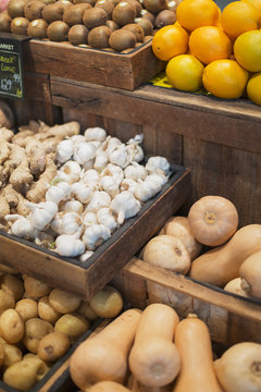 Garlic, ginger, potatoes and butternut squash display in grocery store market