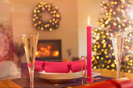 Champagne flute, candle and Christmas cracker on ambient table