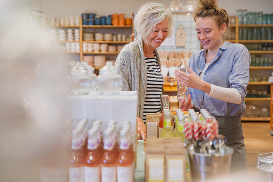 Shop owner showing products to female shopper in shop