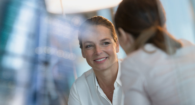 Smiling businesswoman listening to colleague