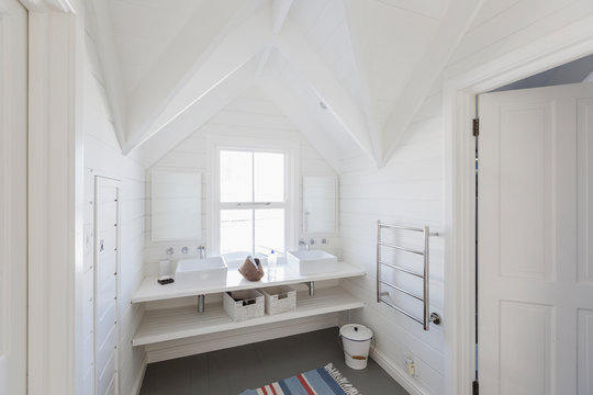 Luxury white bathroom sinks in bathroom with vaulted ceiling