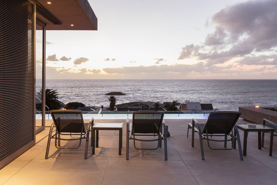 Lounge chairs on luxury patio with sunset ocean view