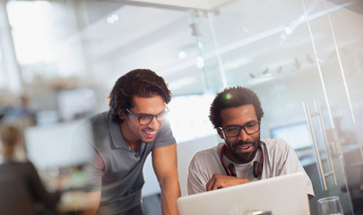 Creative businessmen using laptop in office