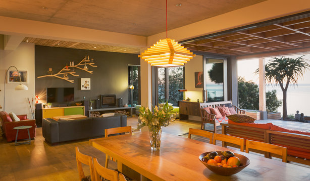 Illuminated modern, luxury home showcase interior dining room open to patio