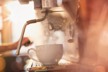 Close up espresso machine filling coffee cup with hot water