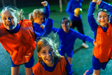 Portrait enthusiastic girls soccer team cheering