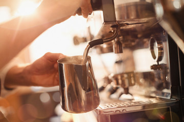Close up barista using espresso machine milk frother