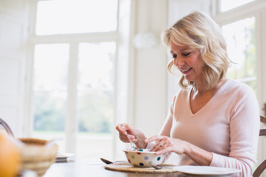 Smiling Mature Woman Eating Breakfast