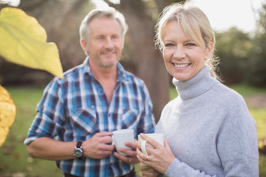 Portrait smiling, happy mature couple drinking coffee in backyard