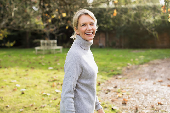 Portrait smiling, confident mature woman in sunny autumn backyard