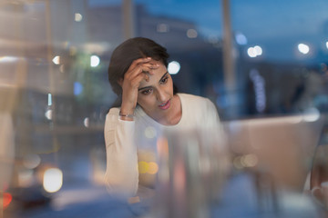 Tired businesswoman working late at laptop in office at night