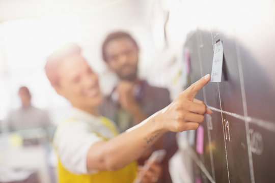 Creative business people planning, scheduling at calendar blackboard