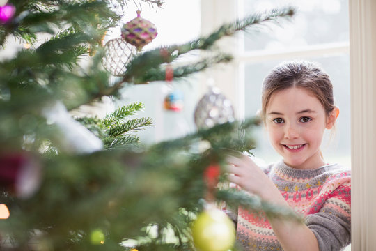 Portrait smiling girl decorating Christmas tree