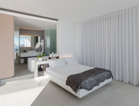 Bed in modern, luxury home showcase interior bedroom with en suite bathroom