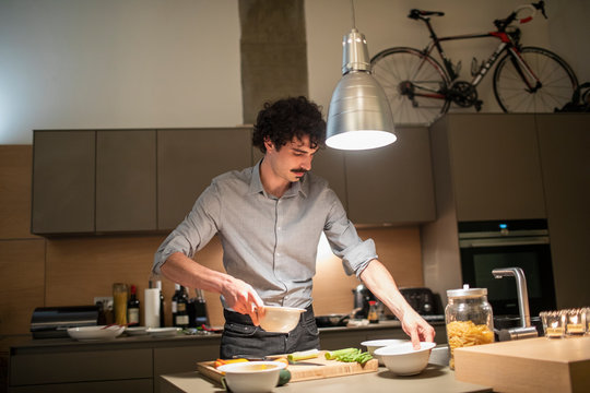 Man Cooking Dinner In Apartment Kitchen