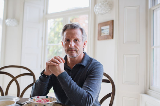 Portrait confident, serious mature man eating breakfast