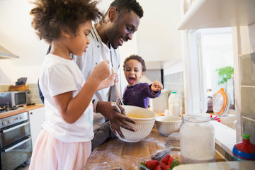 Father and toddler children baking in kitchen