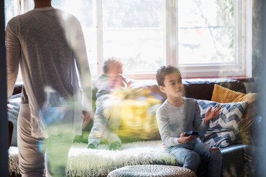 Boy with remote control watching TV in living room