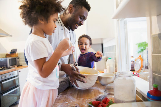 Father and toddler children baking in kitchen
