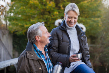 Mature couple drinking coffee in park