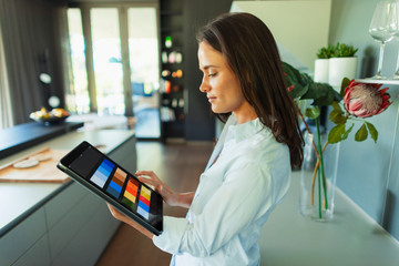 Female interior designer looking at digital color swatches on digital tablet