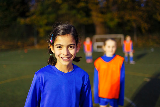 Portrait confident girl playing soccer