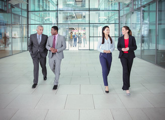 Business people walking and talking outside modern office building