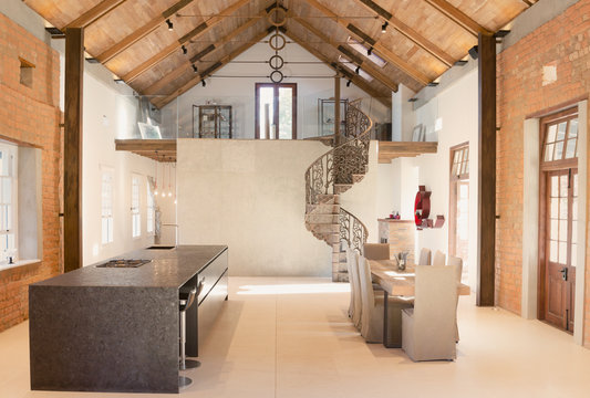 Home showcase interior dining room with wood vaulted ceiling and spiral staircase loft