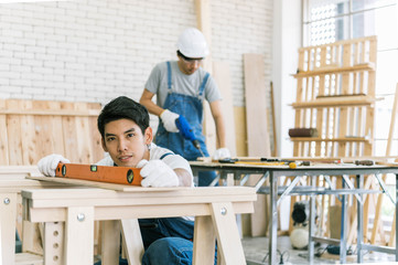 The carpenters are using spokeshave to decorate the woodwork. Carpenter working with plane on table in his workshop.