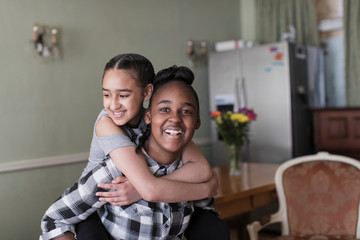 Portrait happy teenage girl friends piggybacking