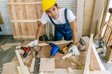 profession, carpentry, woodwork and people concept - carpenter testing wood plank evenness at...