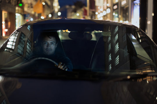 Portrait man driving car at night