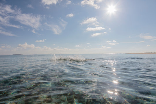 Swimmer splashing in sunny, idyllic ocean, Maldives