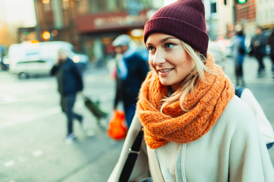Young woman in stocking cap and scarf on urban street