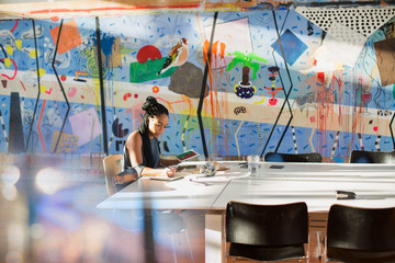 Dedicated, creative businesswoman with digital tablet working in conference room