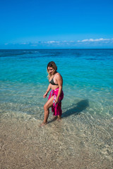 Beautiful young woman walking by the beach