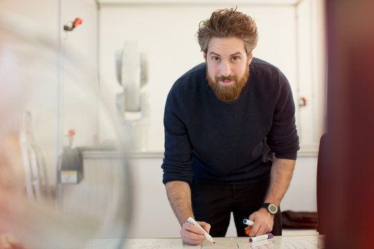 Portrait confident male engineer planning at whiteboard in office