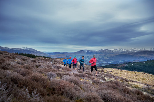 Friends jogging along mountain trail